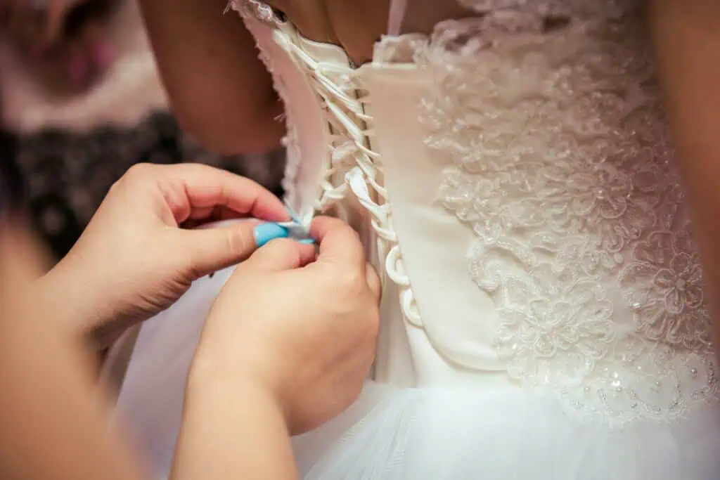 Photo of Woman Fixing the Wedding Gown