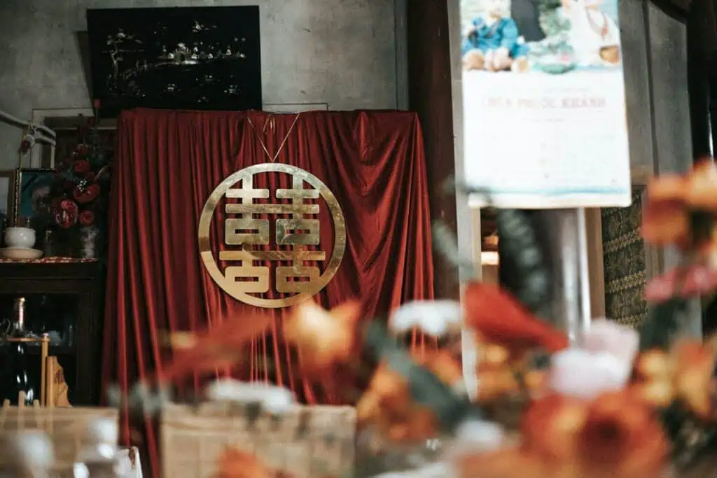 Elegant traditional wedding decoration featuring a Double Happiness symbol against a vibrant red fabric background.