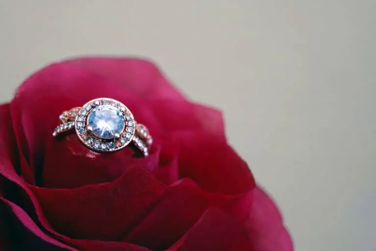 A close-up shot of a sparkling diamond engagement ring nestled in a vibrant red rose, symbolizing love and romance.